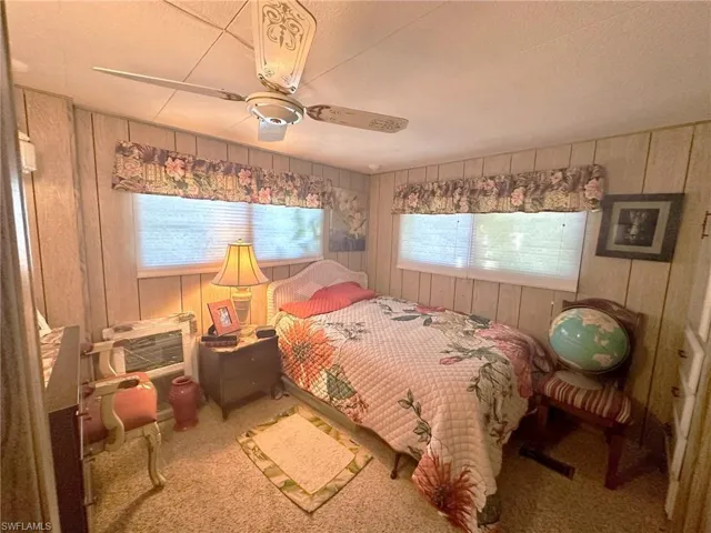 Primary bedroom with ceiling fan, neutral carpet, and built-ins.