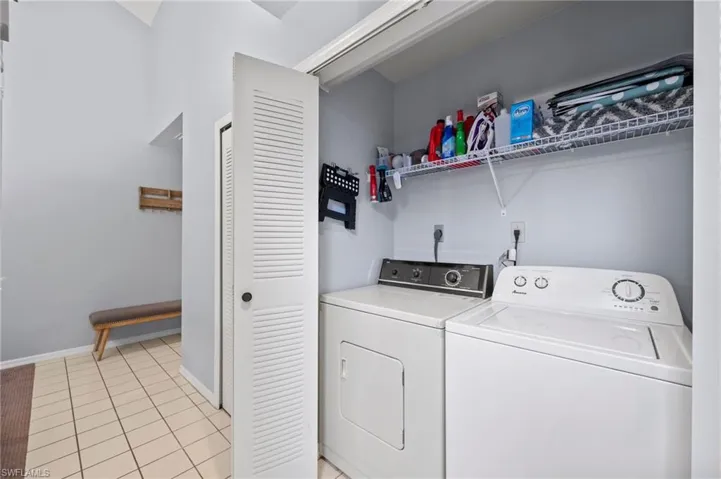 Laundry room featuring washer and clothes dryer and light tile patterned flooring