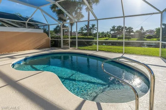 View of pool with a patio, a water view, and a lanai