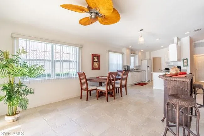 Tiled dining space featuring ceiling fan
