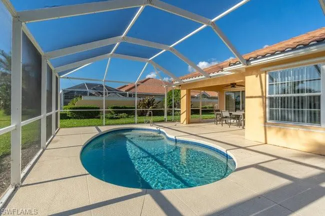 View of pool featuring a lanai, ceiling fan, and a patio