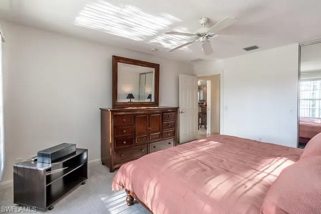 Carpeted bedroom featuring ceiling fan