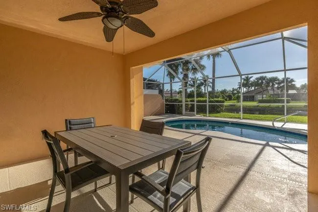 View of pool featuring a lanai, ceiling fan, and a patio area