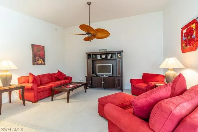 Carpeted living room featuring ceiling fan