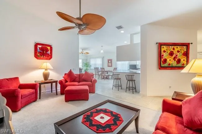 Living room featuring ceiling fan and light carpet