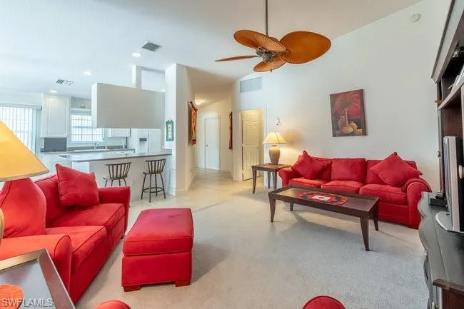 Living room with light colored carpet and ceiling fan