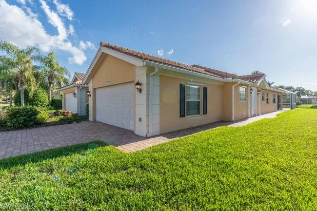 View of property exterior featuring a lawn and a garage