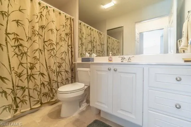 Bathroom featuring vanity, tile patterned floors, and toilet