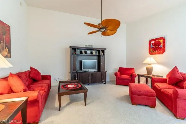 Carpeted living room with ceiling fan