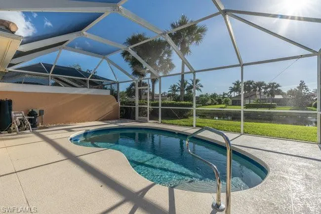 View of swimming pool featuring a patio area, a water view, and a lanai