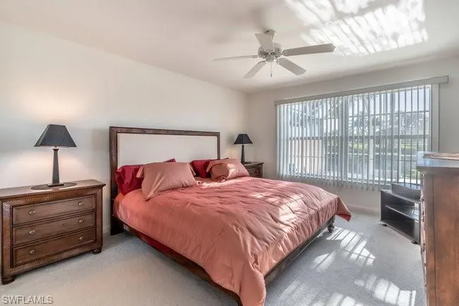 Carpeted bedroom featuring ceiling fan