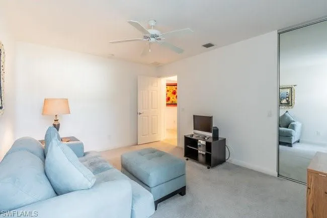 Carpeted living room with ceiling fan