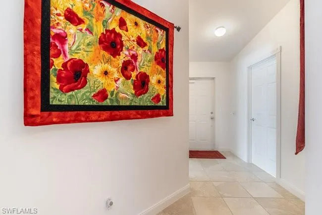 Hallway featuring lofted ceiling and tile patterned floors