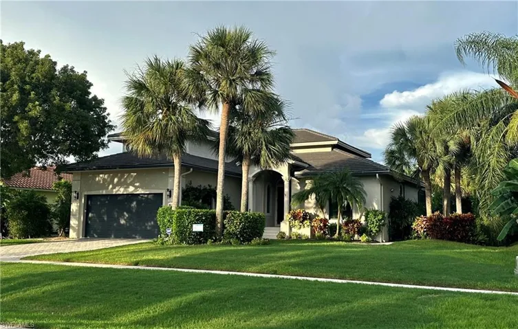 View of front of property featuring a front lawn and a garage