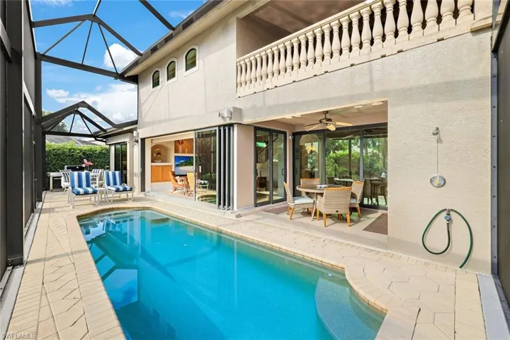 View of pool with ceiling fan, a lanai, a patio, and an outdoor living space