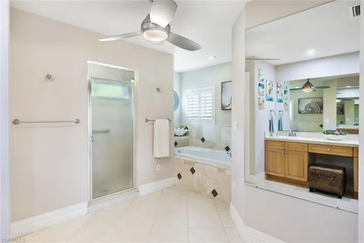 Bathroom featuring tile patterned floors, ceiling fan, vanity, and independent shower and bath