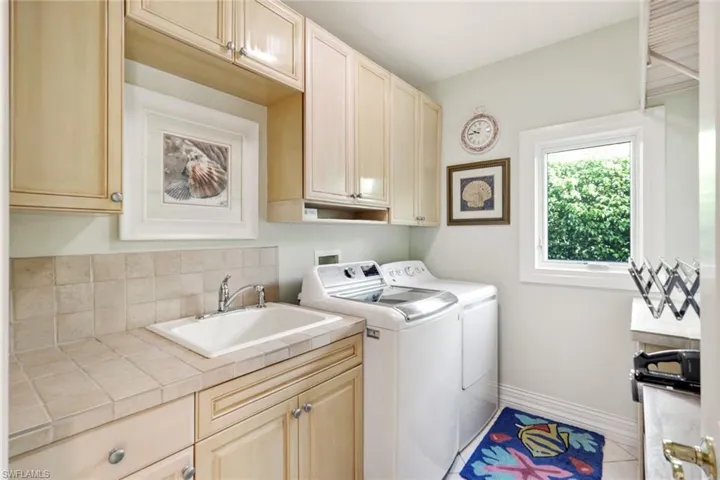 Washroom featuring cabinets, sink, and separate washer and dryer
