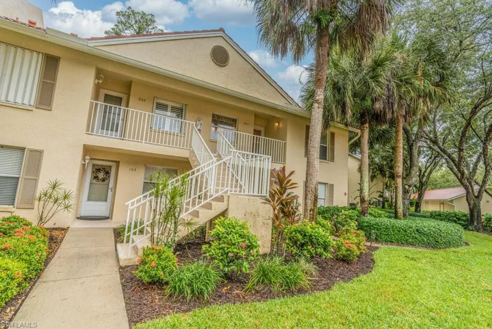 View of front facade featuring a front yard and a balcony