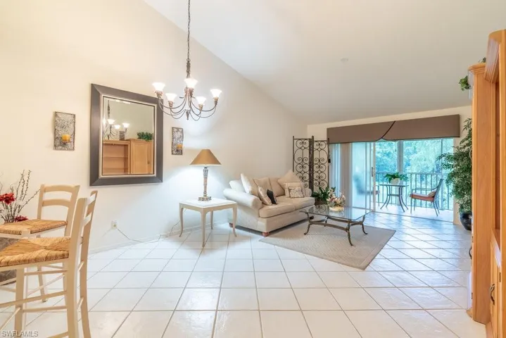 Tiled living room with high vaulted ceiling and an inviting chandelier