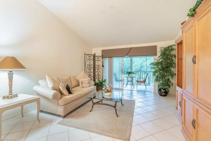 Living room featuring vaulted ceiling and light tile patterned floors