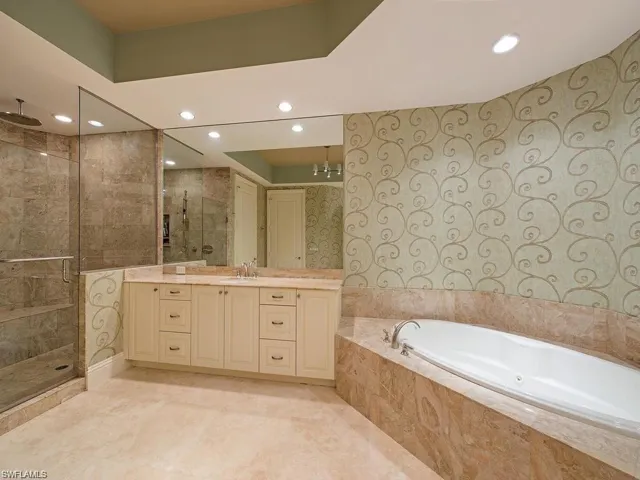 Bathroom featuring plus walk in shower and vanity