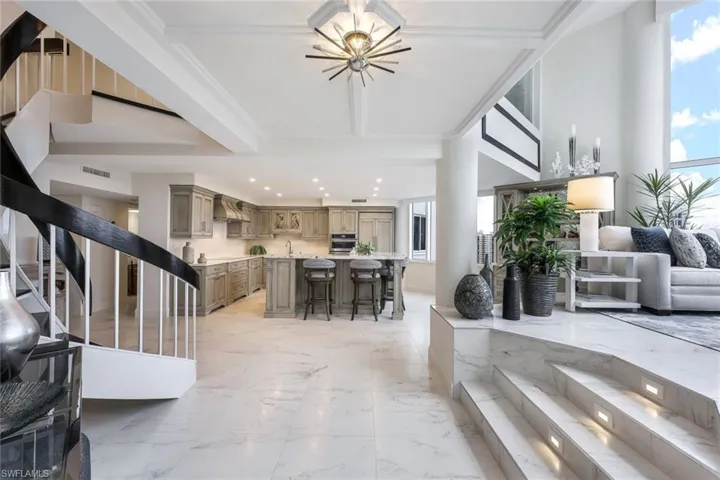 Main area with spiral staircase, family room and view of the kitchen.