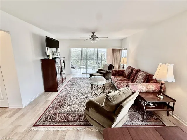 Living room with light wood finished floors and a ceiling fan