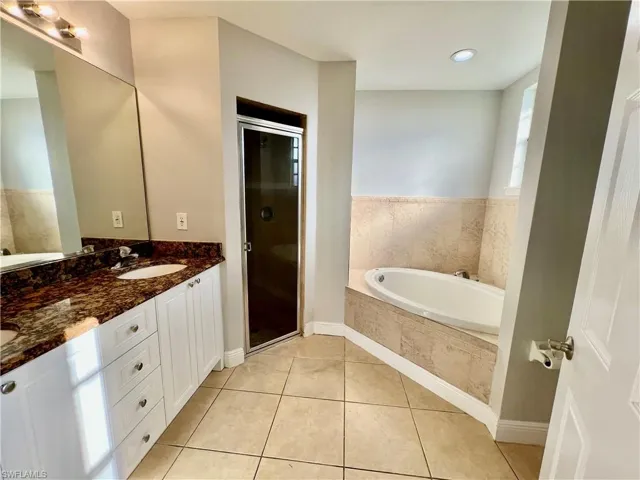 Primary bathroom featuring double sinks, separate shower and garden tub.