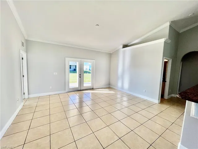 Family room with crown molding, vaulted ceiling, and French doors