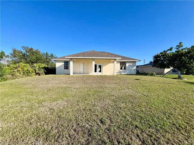 Rear view of house featuring a backyard