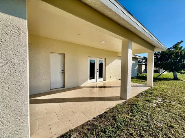 Covered patio with tile floors overlooking the backyard.