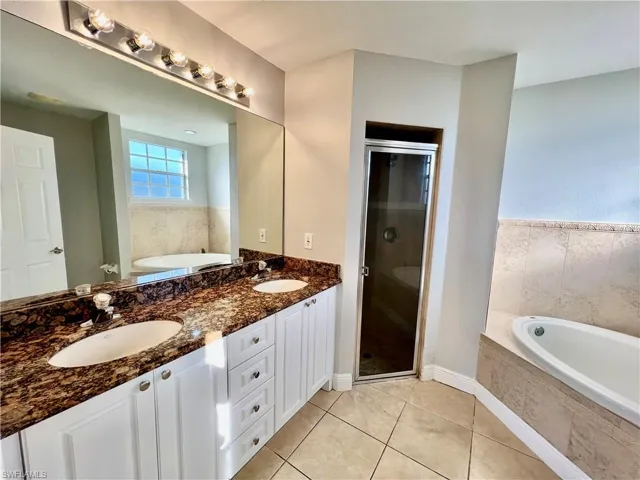 Primary bathroom featuring double sinks, separate shower and garden tub.