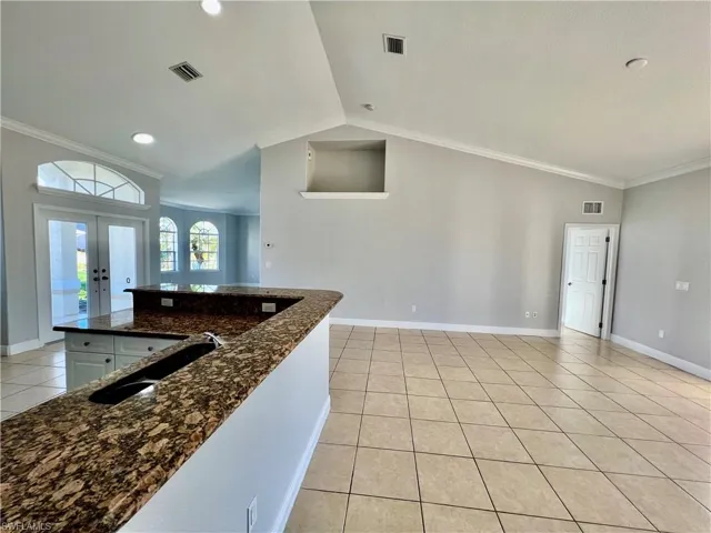 Kitchen and family room with plant shelves and crown molding.