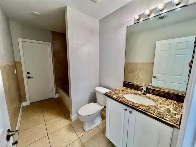 Guest bathroom with GRANITE tops and tile floors.