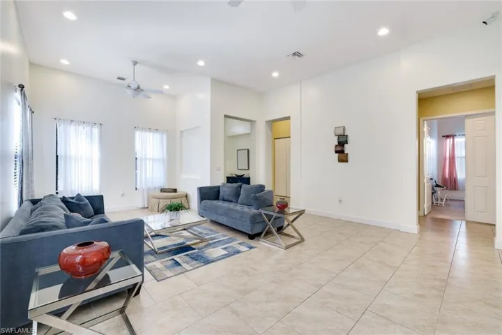 Living area featuring recessed lighting, light tile patterned flooring, and a ceiling fan
