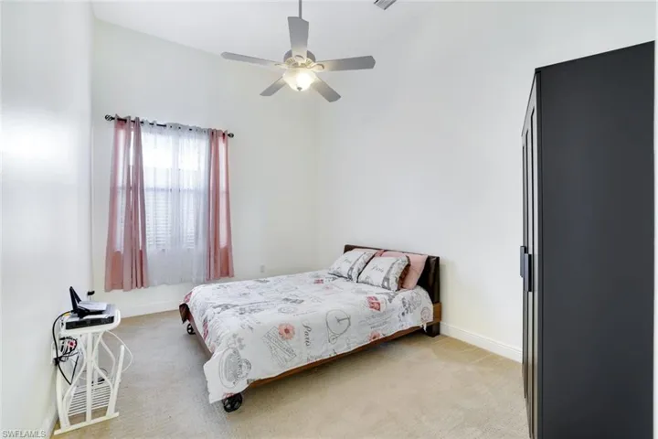 Bedroom featuring light carpet and a ceiling fan