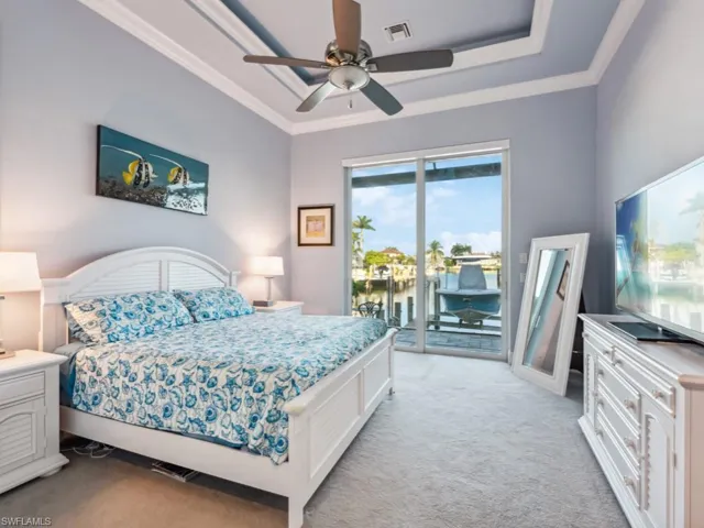 Large Primary Bedroom with 10' tall sliders to lanai, decorative cove lit tray ceiling, 2 largewalk-in closets