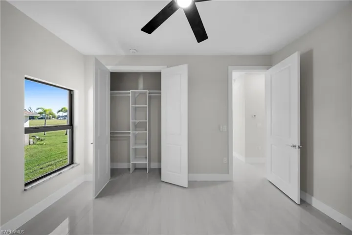Unfurnished bedroom with a closet, a ceiling fan, and light tile patterned floors