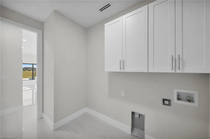 Laundry room with washer hookup, electric dryer hookup, and cabinet space