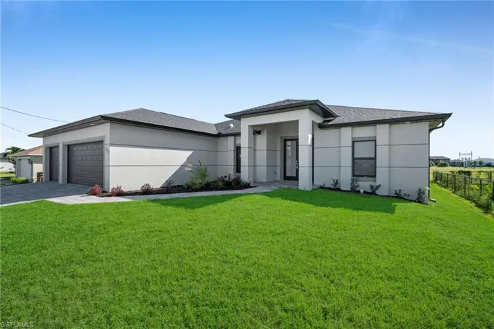 Prairie-style house with an attached garage, roof with shingles, stucco siding, and driveway