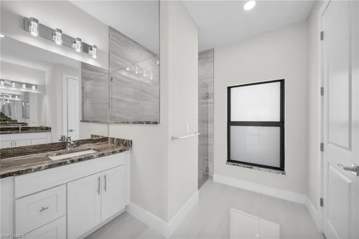 Bathroom with vanity, a walk in shower, and recessed lighting