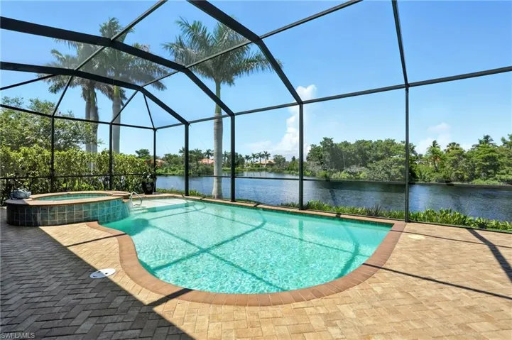 View of swimming pool featuring a water view, a pool with connected hot tub, a sunroom, and a lanai