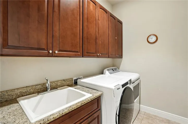 Laundry room featuring cabinet space, independent washer and dryer, and light tile patterned floors