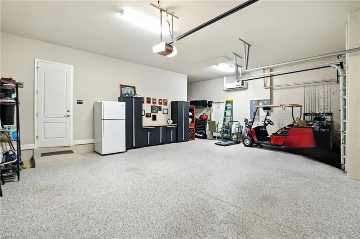 Garage with freestanding refrigerator and a garage door opener