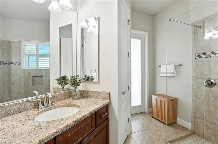 Full bathroom with light tile patterned flooring, vanity, and a walk in shower