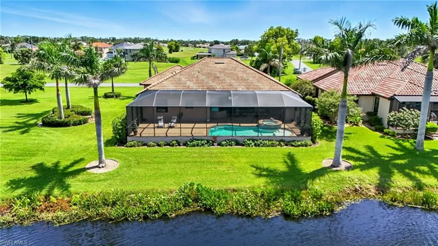 Aerial view of residential area featuring a large body of water and a pool