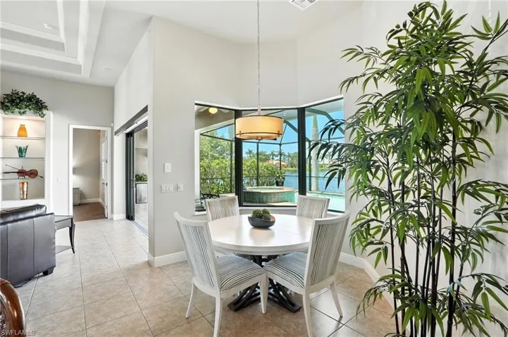 Dining area with light tile patterned floors and a towering ceiling