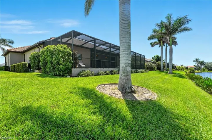 View of green lawn with a sunroom and a lanai