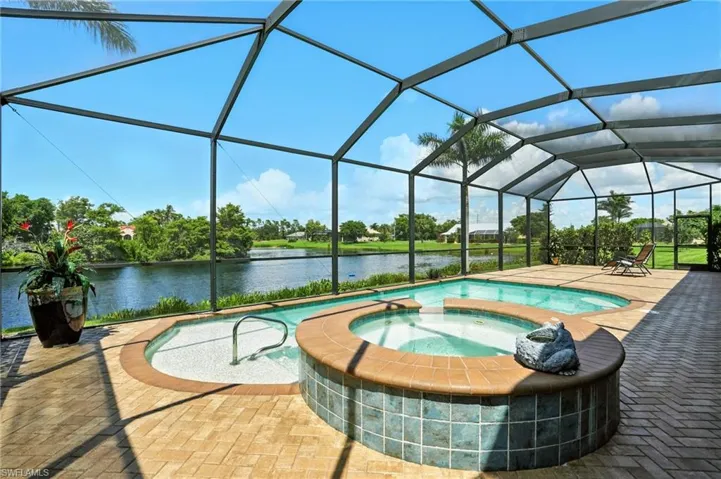 View of swimming pool with a water view, a sunroom, glass enclosure, a patio area, and a pool with connected hot tub