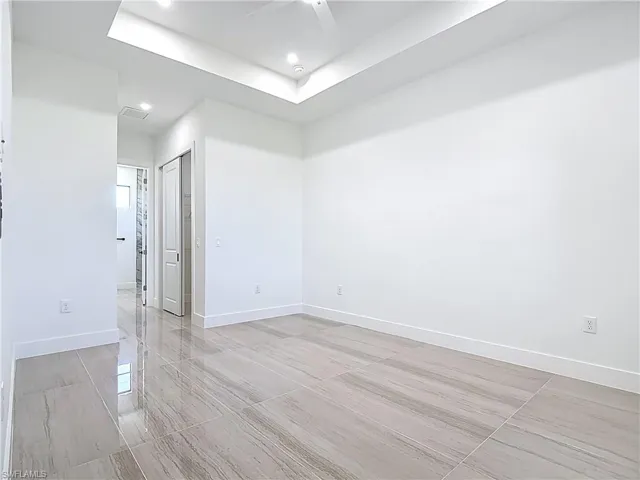 Spare room with a raised ceiling, a ceiling fan, and recessed lighting